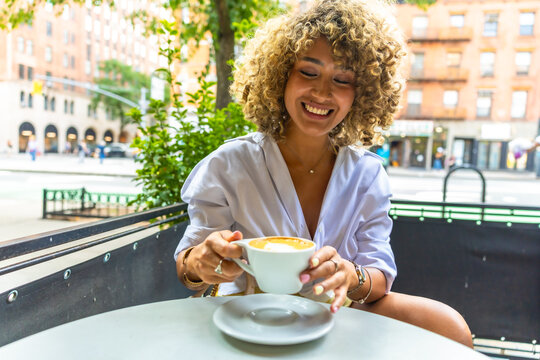 Woman enjoying coffee at outdoor cafe in manhattan