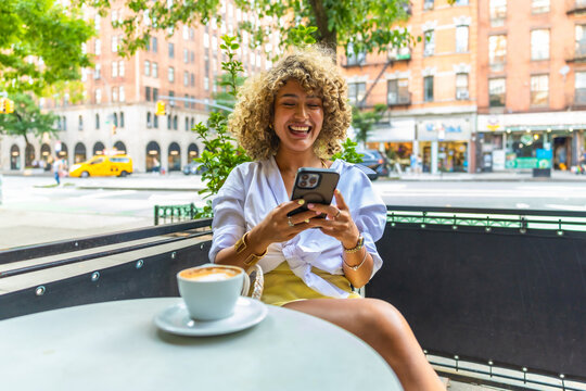 Young woman enjoying coffee on a new york city cafe patio