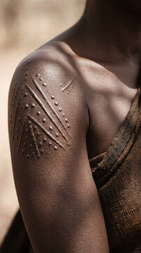 Traditional African tribal scarification body art on shoulder and arm of indigenous tribesman