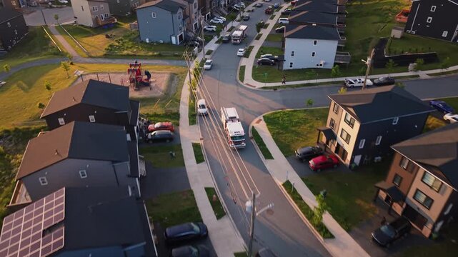 Aerial view captures firefighting trucks in a contemporary Nova Scotia neighborhood as they respond to an emergency, aiding those in need amidst the calm streets of Halifax