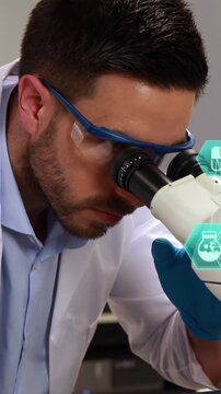 Two globes spinning against male caucasian scientist using binoculars at the laboratory