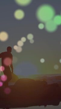 Colorful spot of light over african american couple holding hands walking on the rocks near the sea