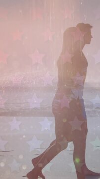 Multiple star icons against caucasian couple walking together on the beach