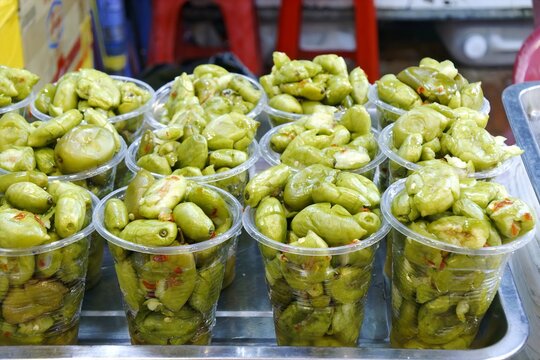 Delicious Ca Na Chua Ngot, Sweet and Sour Pickled Canarium Fruits in Plastic Cups at Street Market