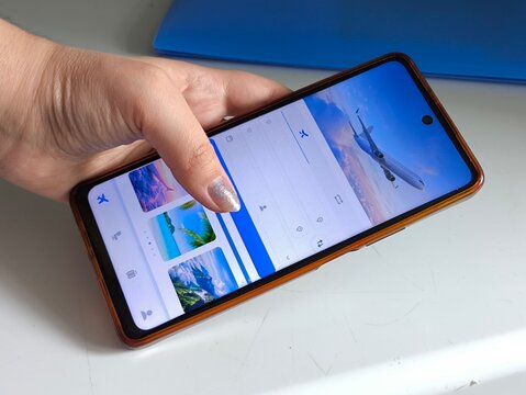 Woman booking a flight ticket online on a smartphone, airline travel, flight booking, vacation abroad and travel planning concept.
