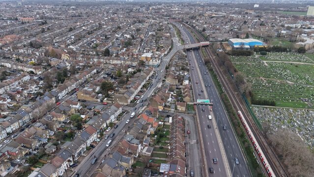 Aerial view of the A12 road in Leyton with traffic flowing towards Leytonstone and a large cemetery on the right, surrounded by dense residential housing in London, England, United Kingdom.