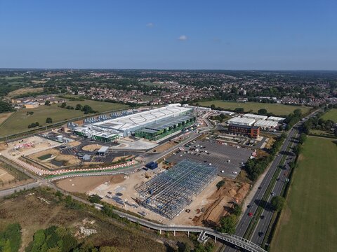Aerial view of Google Data Centre - Waltham Cross featuring industrial buildings, construction, parking, and surrounding green fields in Cheshunt, England, United Kingdom.