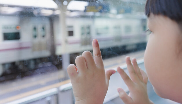 Child Watching Train Passing by Through Window
