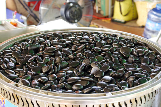 Bep Da Nong hot stone cooking equipment featuring a large metal pot filled with smooth black pebbles