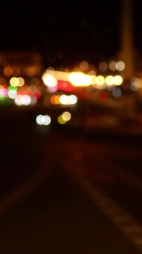 Nighttime scene of an urban street with blurred lights and reflections