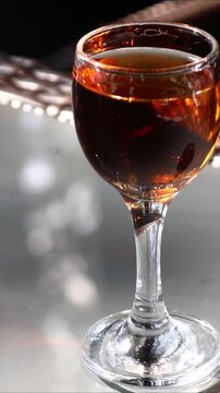 A glass of wine sits on a table, ready to be enjoyed