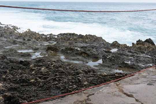 Jagged limestone shore and turquoise Caribbean water at Providencia Island in Providencia, Colombia