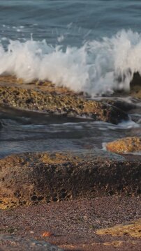 rocky outcropping near the ocean, with waves crashing in the background