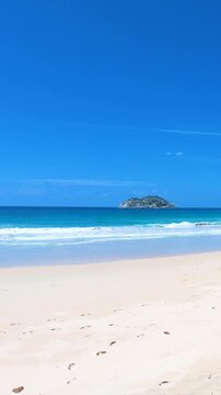 Vertical panoramic view of Anse Louis in Seychelles showing turquoise water, white sand, tropical vegetation and scenic coastline on Mahe Island.