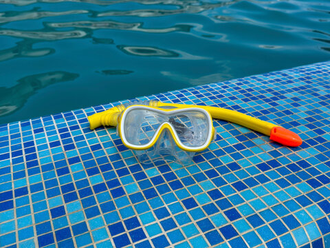 Snorkeling equipment on a swimming pool edge with copy space, summer vacation and water recreation concept.