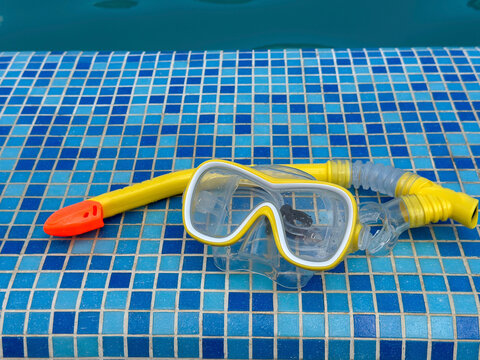 Snorkeling equipment on a swimming pool edge with copy space, summer vacation and water recreation concept.