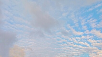 Beautiful cirrocumulus clouds looking like fish scales in the afternoon sky over a rural village. © Berti