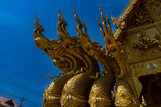 Golden Naga sculptures at Wat Sri Panton in Nan Province, Thailand, showcasing ornate Buddhist architecture, sacred craftsmanship and Northern Lanna heritage