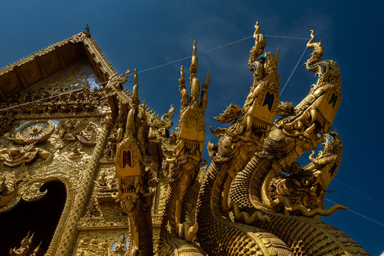 Golden Naga sculptures at Wat Sri Panton in Nan Province, Thailand, showcasing ornate Buddhist architecture, sacred craftsmanship and Northern Lanna heritage