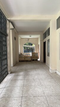 A long empty corridor with a gate and stacked wooden boxes