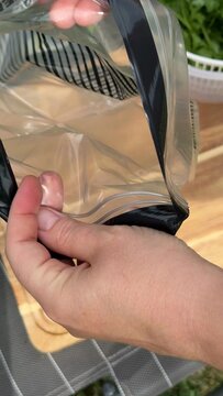 Close up view of clear plastic packaging materials resting on a wooden surface, suggesting retail organization or storage solutions, perfect for craft or cosmetic display
