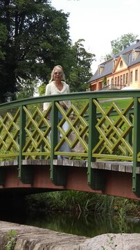 Woman on a bridge in the park. Vertical design in 9:16 ratio. Smartphone and social media ready.	