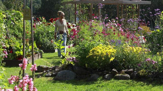 Woman walking in a beautiful blooming flower garden