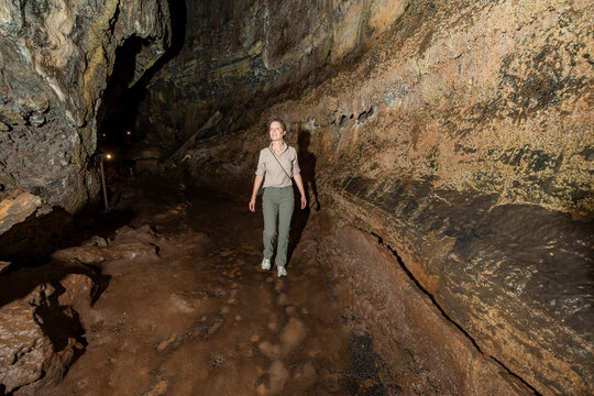 Tourist explore volcanic cave in Galapagos Islands, Ecuador