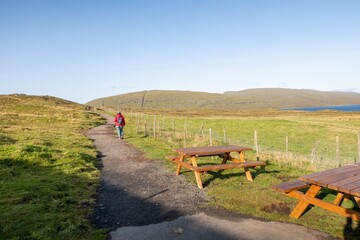 Fototapeta premium Woman hiking path in Faroe Islands landscape