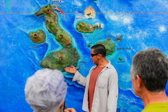 Tourist guide explains Galapagos Islands map in Ecuador