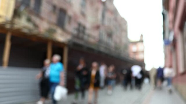 A blurry image of people walking down a street