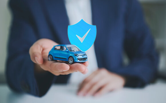 Car insurance protection with businessperson holding model car to represent vehicle coverage financial security risk management accident protection trust and reliable automotive insurance.