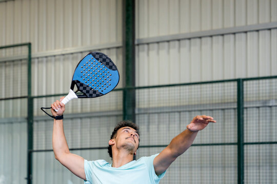 Padel player serve during indoor tournament match