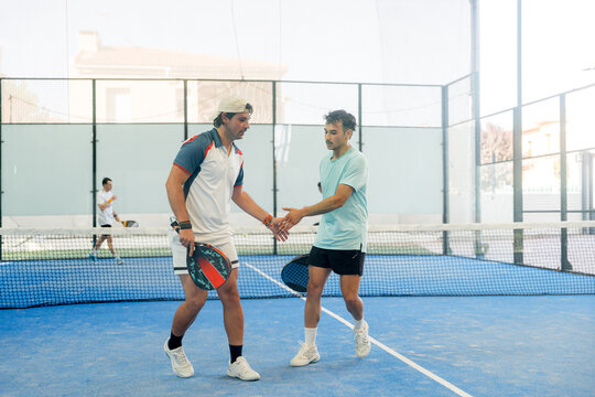 Padel player shake hand after indoor tournament match