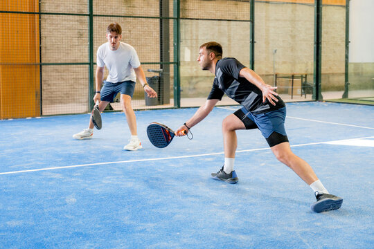 Padel doubles players compete during an indoor tournament