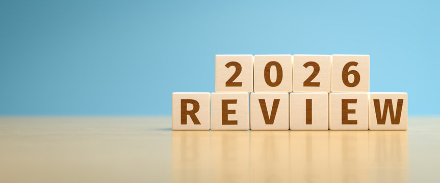 Wooden toy cubes forming the text "2026 REVIEW". Concept for reviewing what happened in the year 2026.