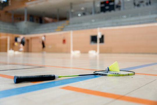 Badminton racket and shuttlecock detail on indoor tournament court