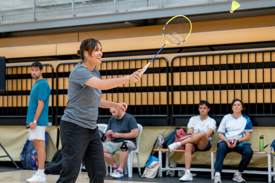 Woman compete in indoor badminton tournament match