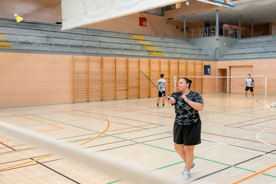 Woman playing badminton during indoor tournament match