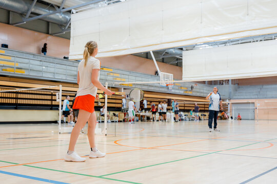 Woman compete in indoor badminton tournament match