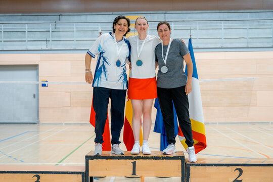 Women badminton medalists celebrate on tournament podium