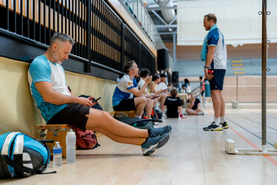 Badminton player use smartphone during tournament break