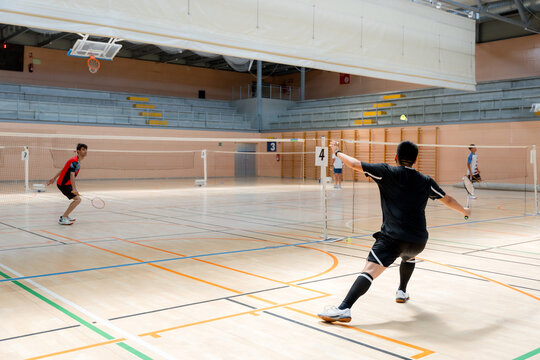 Badminton tournament player return shuttlecock on indoor court