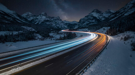 Fototapeta premium Starry night sky over snowy mountain road with vibrant car light trails.
