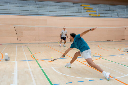 Badminton player return shuttlecock during indoor tournament match