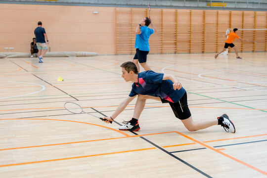 Badminton player reach for shuttlecock during indoor tournament