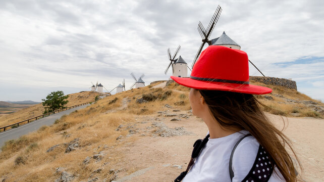 Traveler in red hat views Consuegra windmills in Spain