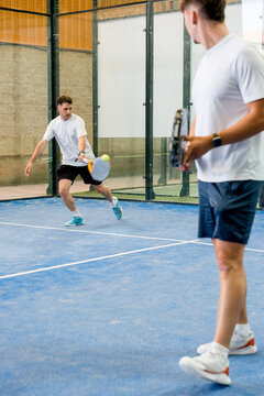 Padel doubles match with players on indoor court