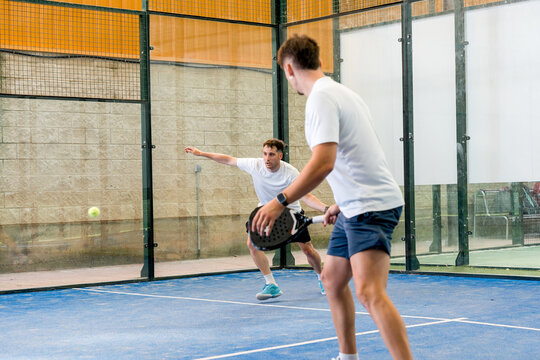 Padel doubles match with players on indoor court