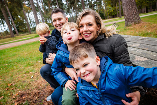 Happy family with three boys enjoying park together